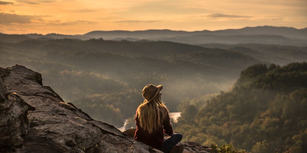 happy person meditating in a serene natural setting